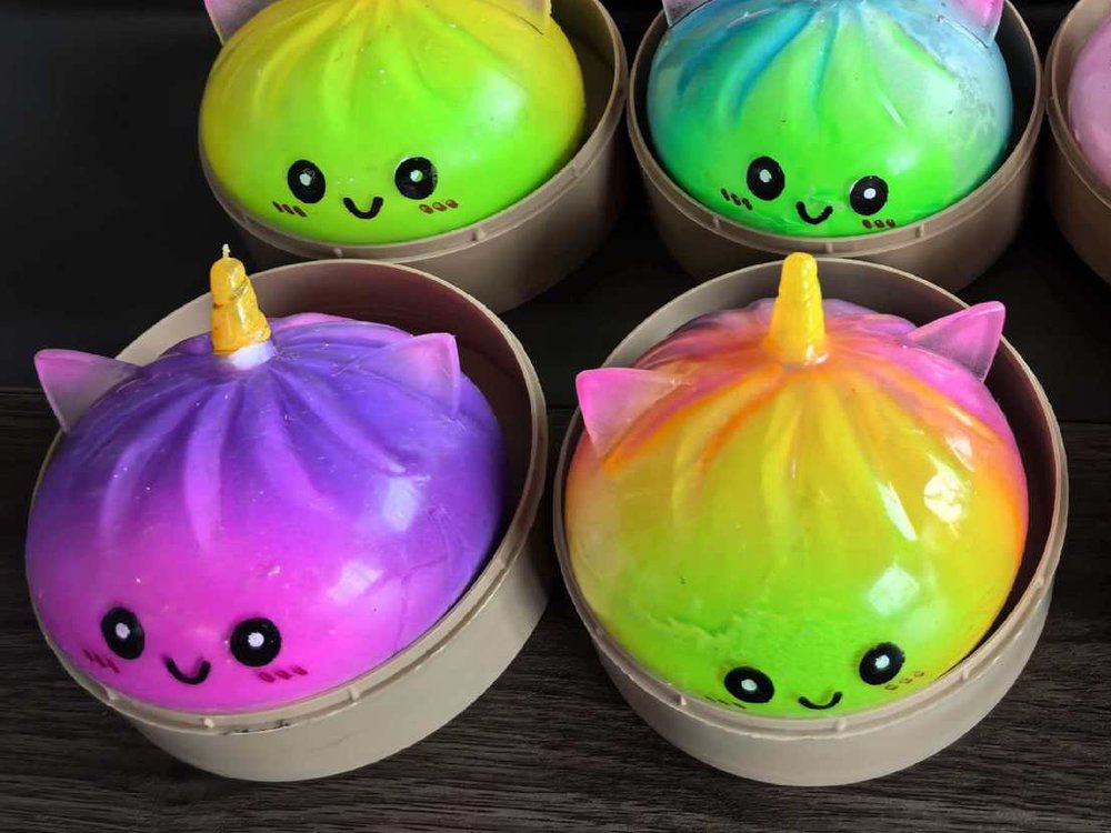 Four rainbow unicorn buns in different colors, each in its own little steamer